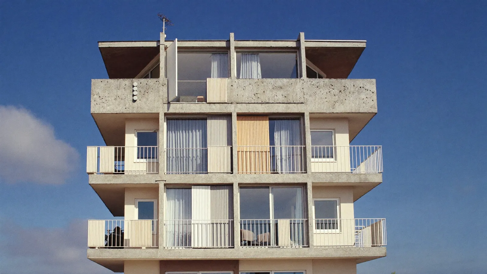 Immeuble d'habitation des années 1960-1970 à Béziers avec balcons, sous un ciel bleu méditerranéen